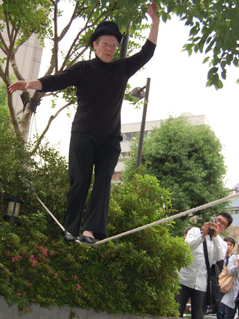 桜丘公園で綱渡りを披露した大道芸人フィリップ・プティさん。通行人や観客からは拍手も