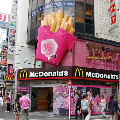 ピンク一色に衣替えした「マクドナルド渋谷センター街店」外観。ポテトの上に「Tシャツ」も