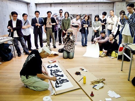来場者が見つめる中、「弓道士魂」と揮毫する平田弘史さん（昨年の「戦国ART祭」で）