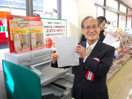 新型マルチコピー機を使って「住民票写し」交付のデモンストレーションを行う桑原敏武渋谷区長