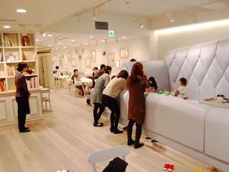 ソファの遊び場で子どもを遊ばせる人や食事をする人などの姿が見られる店内