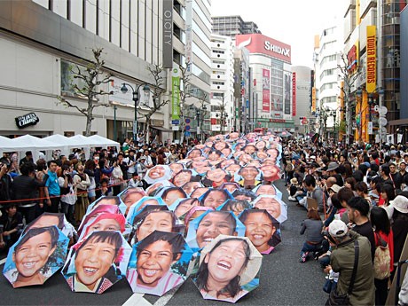 専門学校生やミクシィのコミュニティーで募った参加者ら100人が傘を手にしたパフォーマンス