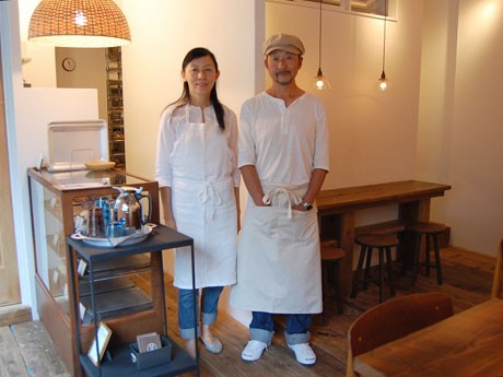 白や木の質感を大事に「ナチュラルな雰囲気」に仕上げた「ココドーナツ」の店内。写真左が明石露香さん、右は夫の明石泰一さん