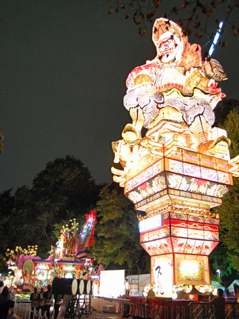 「青森四大祭り」の点灯式が行われた。明治神宮第一駐車場には23メートルの「五所川原立佞武多」（手前）と豪華絢爛（けんらん）「八戸三社大祭」（奥）を展示