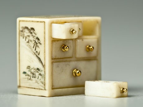 象牙をくりぬいて作った「象牙箪笥」（8.5×5.4×8.4ミリ）。引き出しがすべて引き出せるほか、中にはヒョウタンやこま、サイコロなどが収められている。