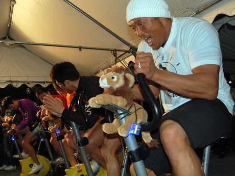 自転車をこいで人力発電する秋山成勲さんら