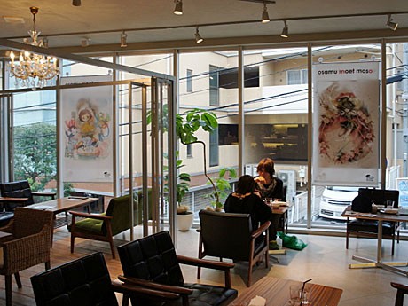 2階の喫茶スペースには参加クリエーターが手塚治虫作品を「アキバ化」した絵画作品のパネルもディスプレー