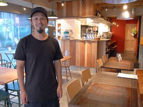 木目を基調に植物やオレンジ色など自然をイメージした色を取り入れた店内。写真はオーナーの田嶋大輔さん
