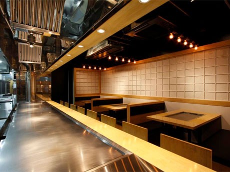 障子柄のしっくいの壁やカウンター席の前のは5.3メートルの鉄板が特徴的な店内