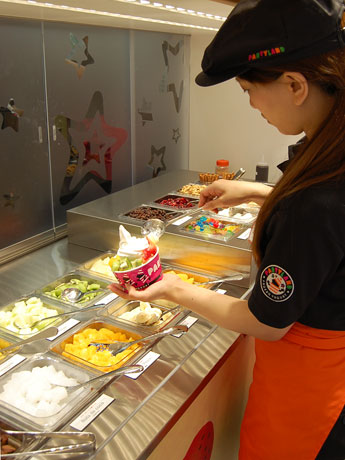 フローズンヨーグルトやフルーツなどのトッピングは来店客自身が自由に盛ることができる