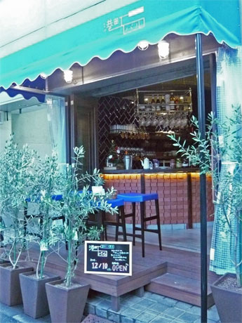 ブルーのオーニングテントが目を引くファサード。エントランス近くは立ち飲みスペース