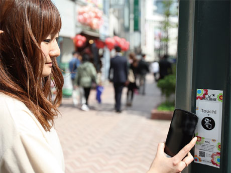街路灯に掲出するICタグ内臓シールにNFC対応スマートフォンをかざすイメージ&copy;2013Shibuya Television.All right reserved.