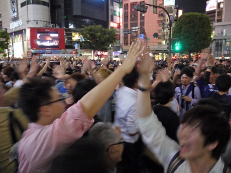 横断歩道を通行中にハイタッチでW杯出場を喜び合う若者ら
