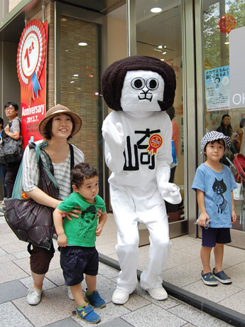 来店客との写真撮影に応じるオカザえもん