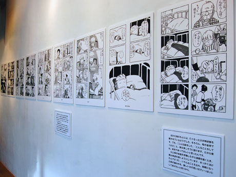 パネル化した漫画25枚と岡野さんの解説を展示する場内