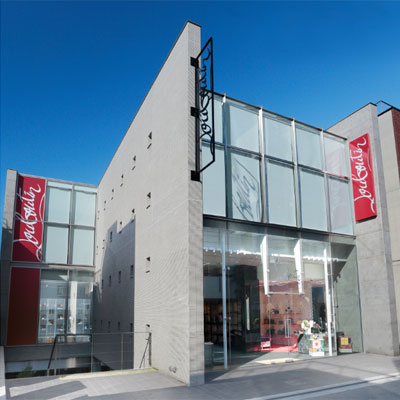 赤いサインを掲出する店舗外観