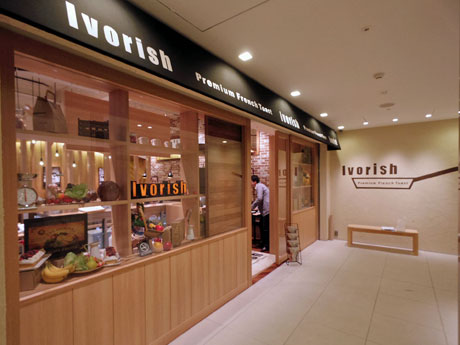 地階に位置する店舗外観。壁面にはフライパンなどを描いたロゴを掲出する