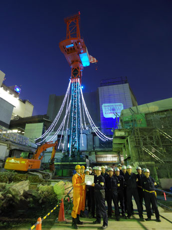 クレーンを活用したイルミネーション。解体工事事務・所所長の永持理さん（手前左）らが点灯
