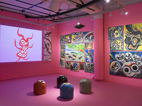 ピンクの壁面に囲まれた空間に油彩などを展示する