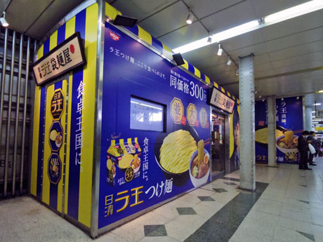 青色と黄色のストライプに西島秀俊さんのビジュアルが目を引くファサード