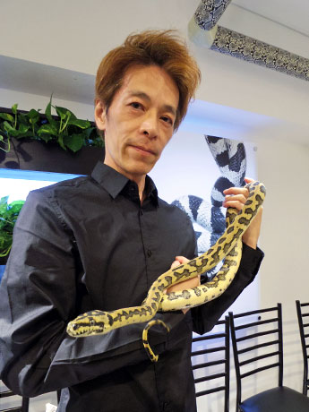 カーペットニシキヘビの「ジャガー」を抱く金子ヒサミツ社長