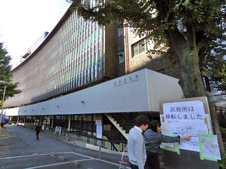 誤って旧庁舎を訪れた人に仮庁舎を案内する区の職員