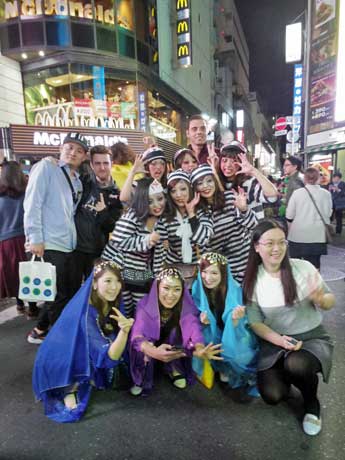 外国人旅行客との写真撮影に応じる仮装姿の若者たち