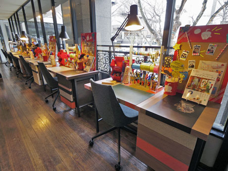 コラージュやアニメ作画などデスクワークを体験できるデスクが並ぶ店内