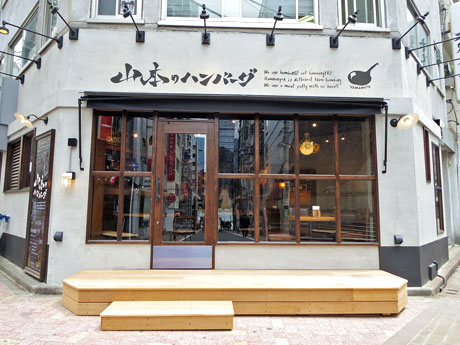 モルタルの壁面に窓を大きくとった店舗外観