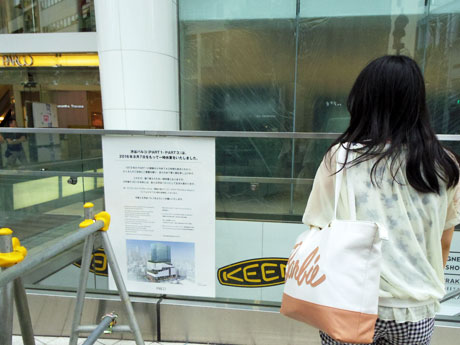 休業を知らせるポスターに足を止める来街者