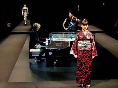 YOSHIKIさんら（中央左）が演奏する中で行われたショーにはモデルの秋元梢さん（手前）も登場