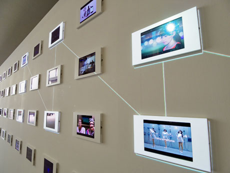 iPad120台で過去の取り組みを紹介する場内。白い線の映像で同様のプロジェクトをつないでいる