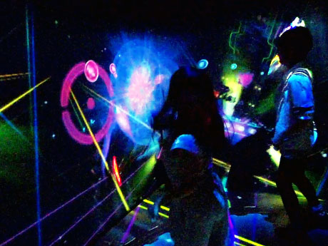 スティック型のコントローラーを振って光のターゲットを打つ