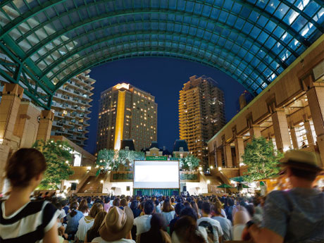 広場に敷いた人工芝に座って映画を見る