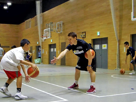 アドバイスを交えながら小学生たちにバスケットを教える山内盛久選手（中央）