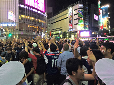 ハイタッチをしながら横断歩道を渡りW杯出場決定を喜ぶサポーターたち