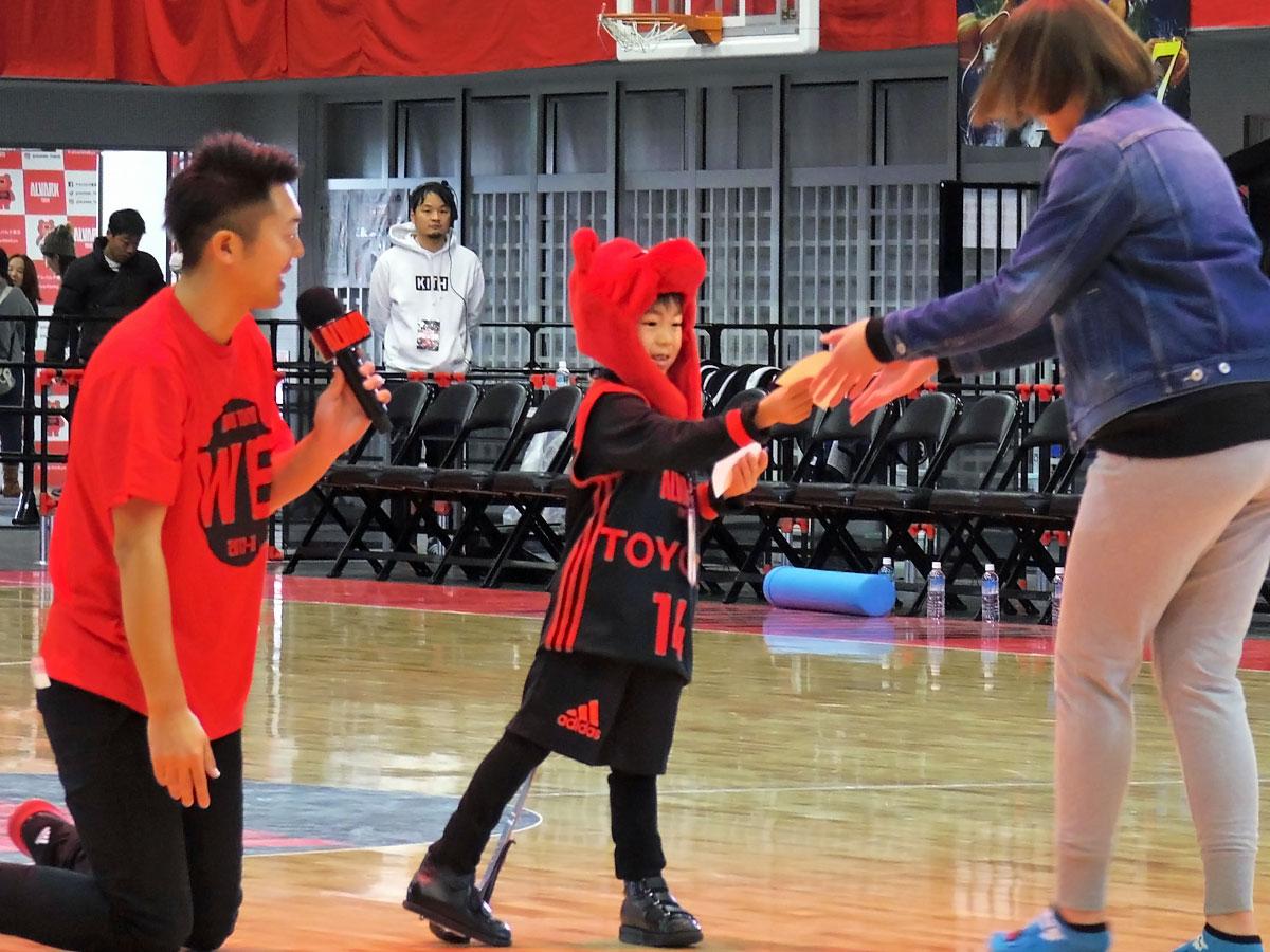 来場客にステッカーを手渡す手伝いをした人形櫂世君（中央）