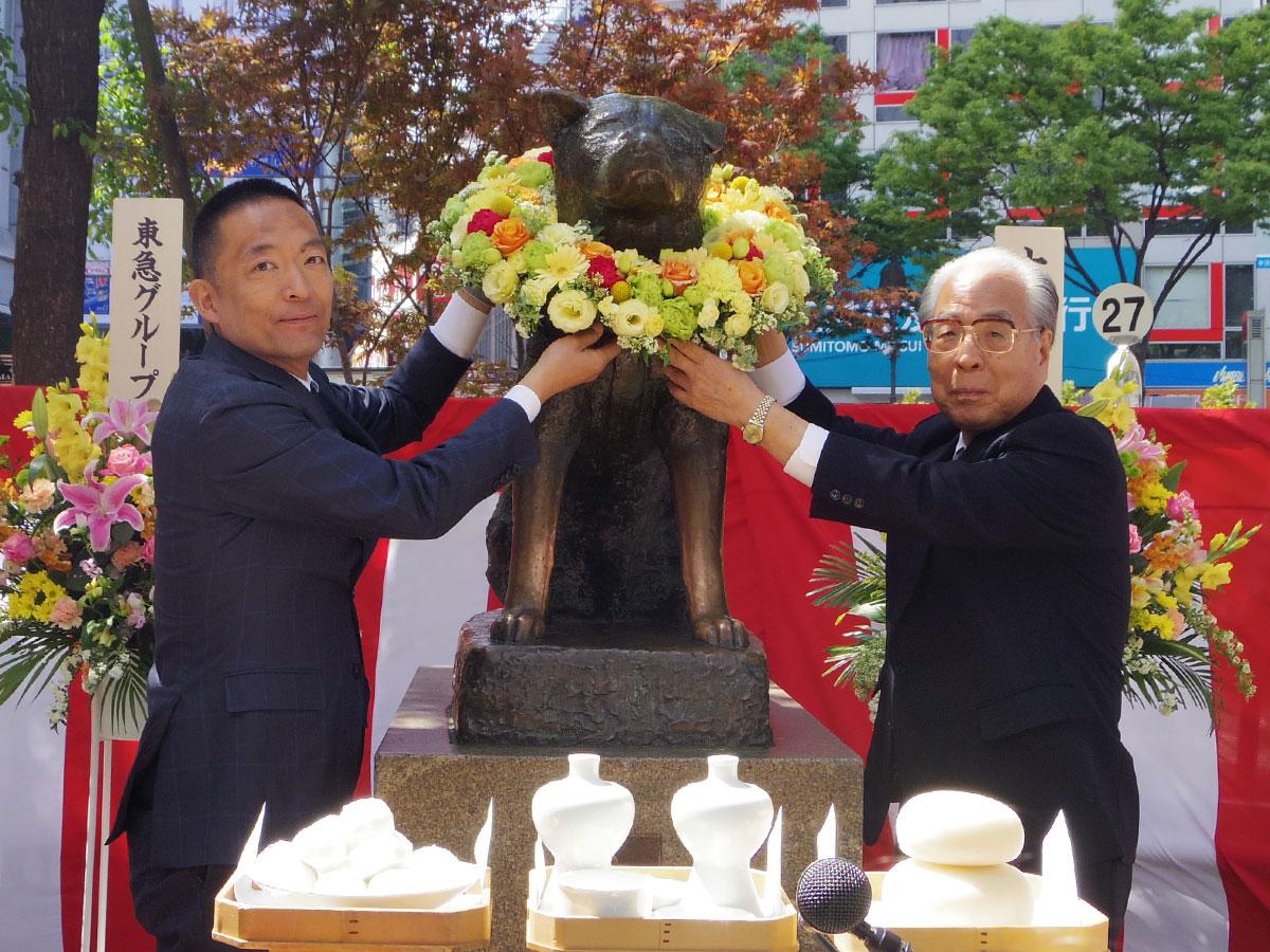 ハチ公像に花輪を献上した（左から）長谷部健渋谷区長と忠犬ハチ公銅像維持会・上條清文会長