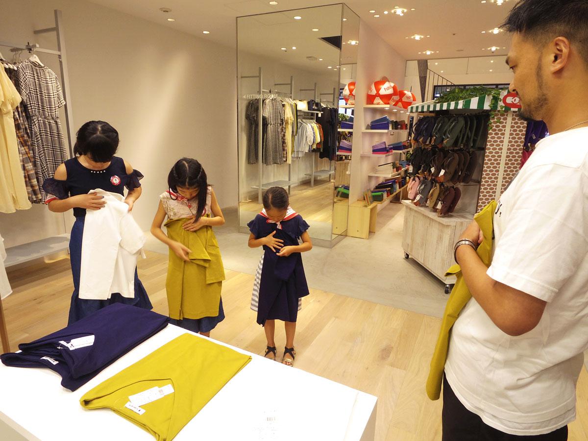 スタッフ指導の下、Tシャツを畳む練習をする参加児童たち
