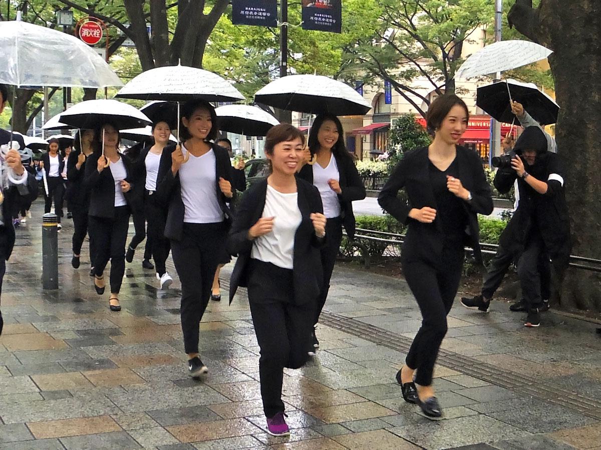 スーツを着て表参道を走る女性たち