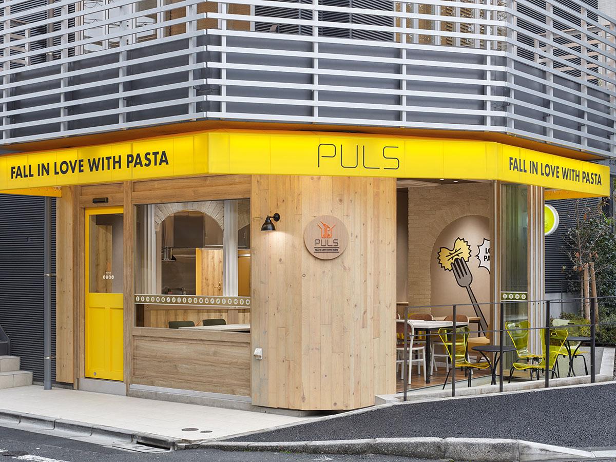 パスタの色から派生したブランドカラーの黄色が目を引く店舗外観