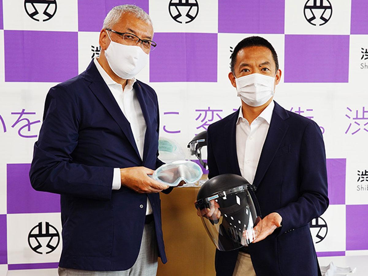 マスクやフェースシールドなどを受け取る長谷部健渋谷区長（右）