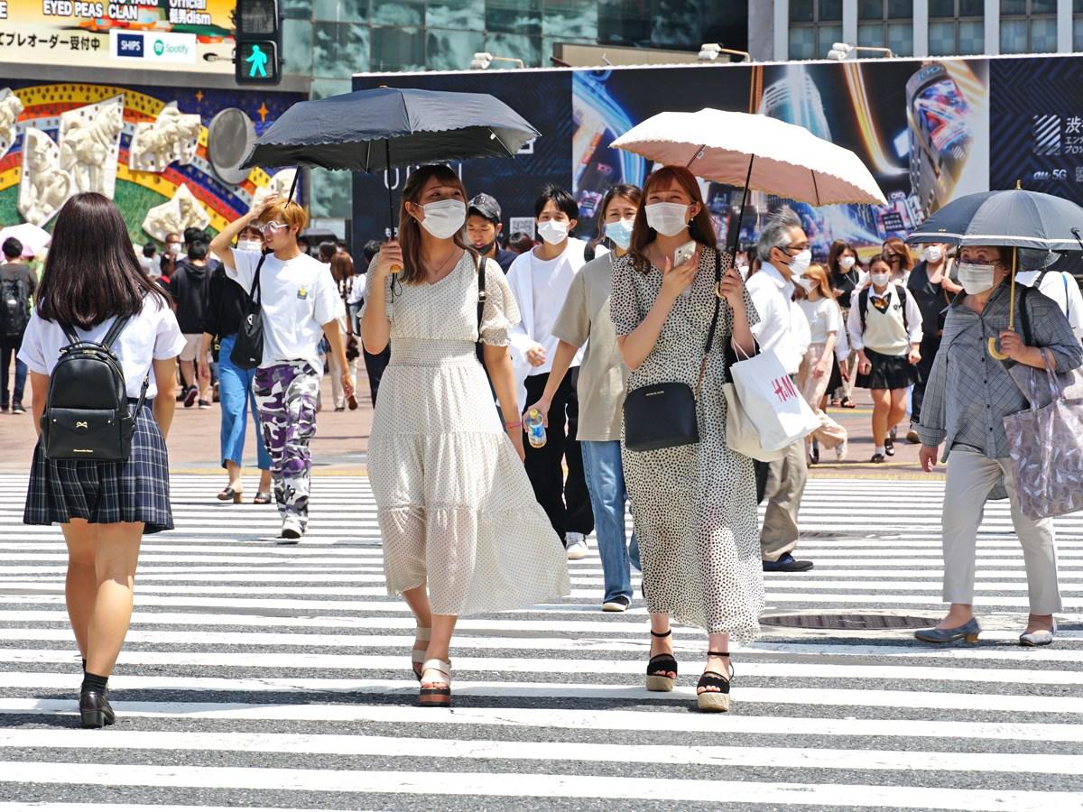 渋谷駅前スクランブル交差点を暑さの中マスク姿で行き交う人々