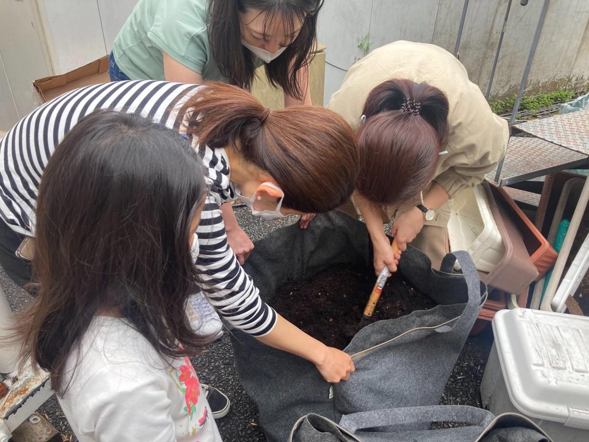 各家庭から持ち寄ったコンポストを世話する様子（表参道での活動より）