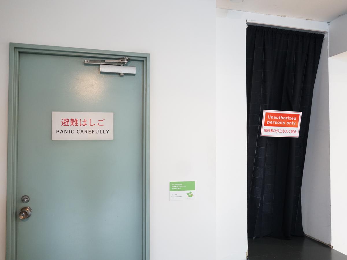 避難はしごの看板には「PANIC CAREFULLY（気を付けパニックになって）」と併記されている