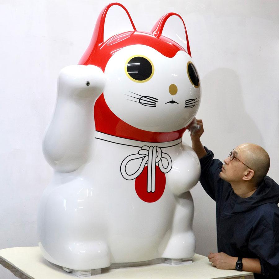 修復が完了した「渋谷猫張り子」を磨き上げる作者の吉田朗さん