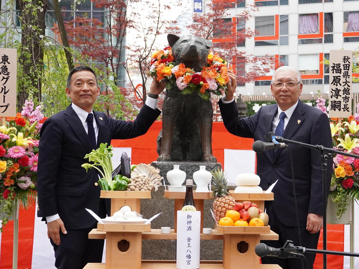 銅像に花輪をかけた（左から）長谷部健渋谷区長と忠犬ハチ公銅像維持会の星野浩一会長