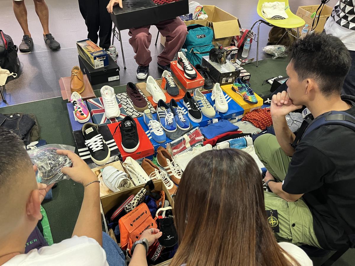 スニーカーなどを手にする客ら（会場内の様子）