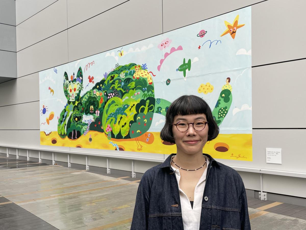 ヒカリエデッキに設置された作品（写真奥）の前に立つ岡田杏里さん