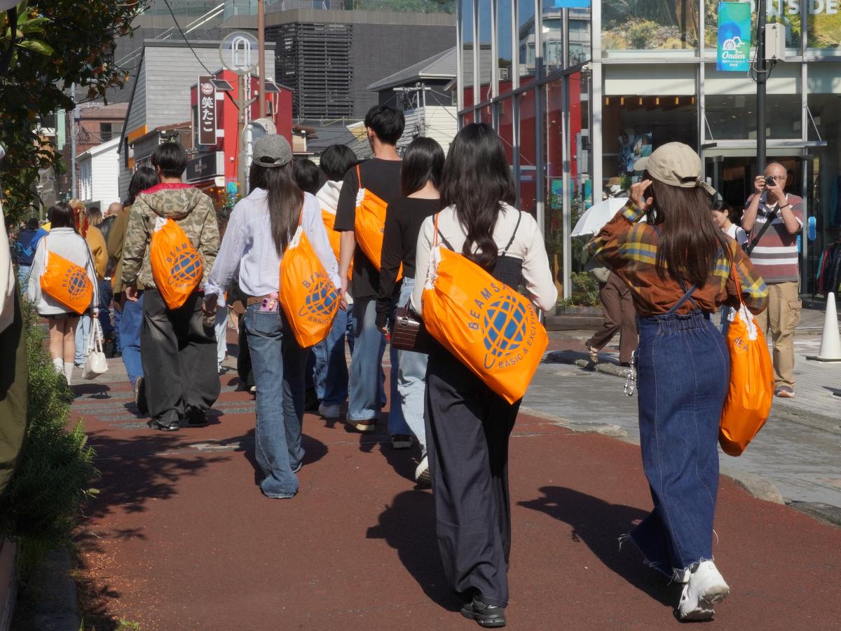 オレンジショッパーを持った人たちがキャットストリートなどを練り歩いた